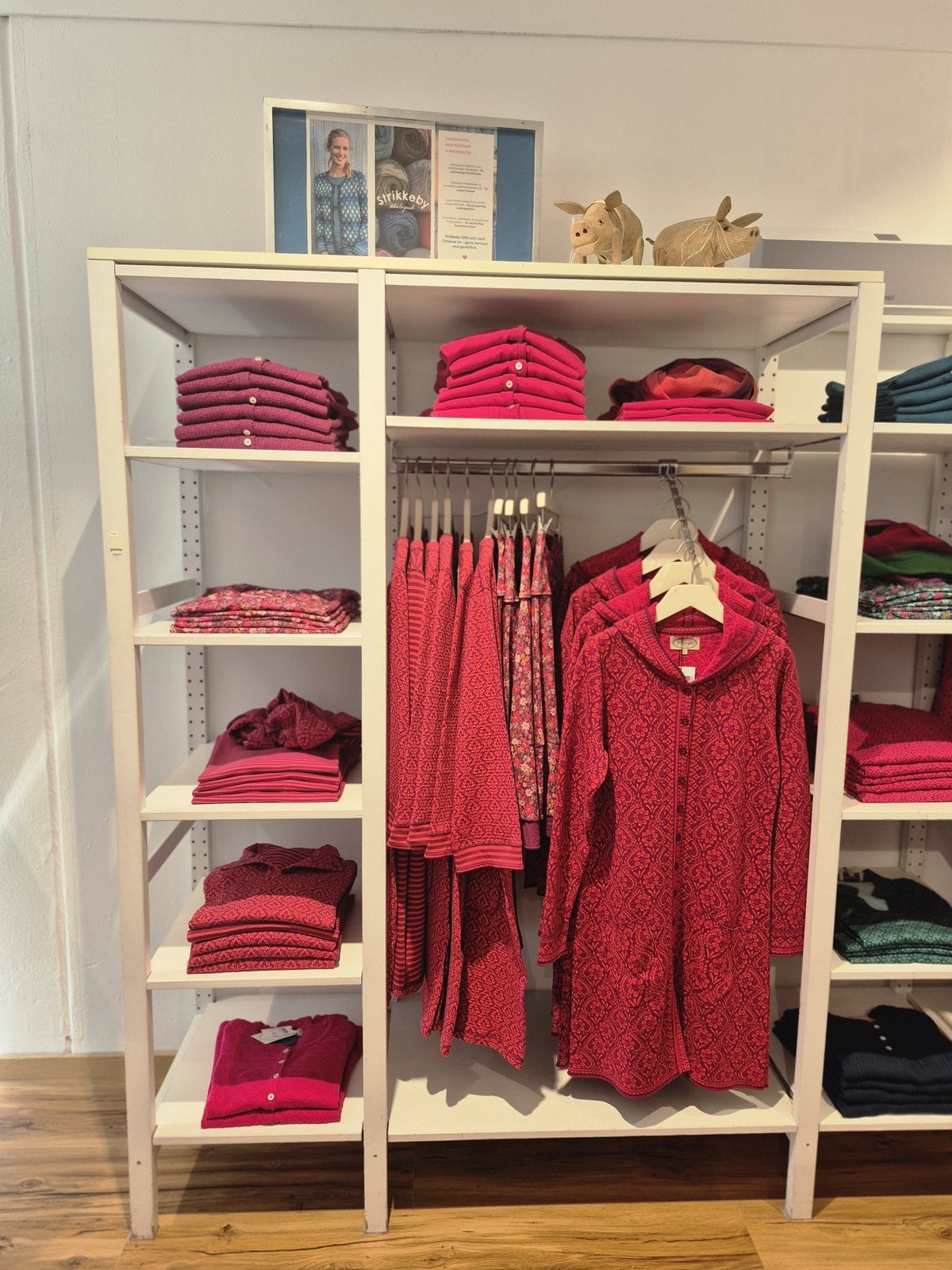 Farbige Kleider und ausgewählte Stücke auf Bügeln in der Boutique.