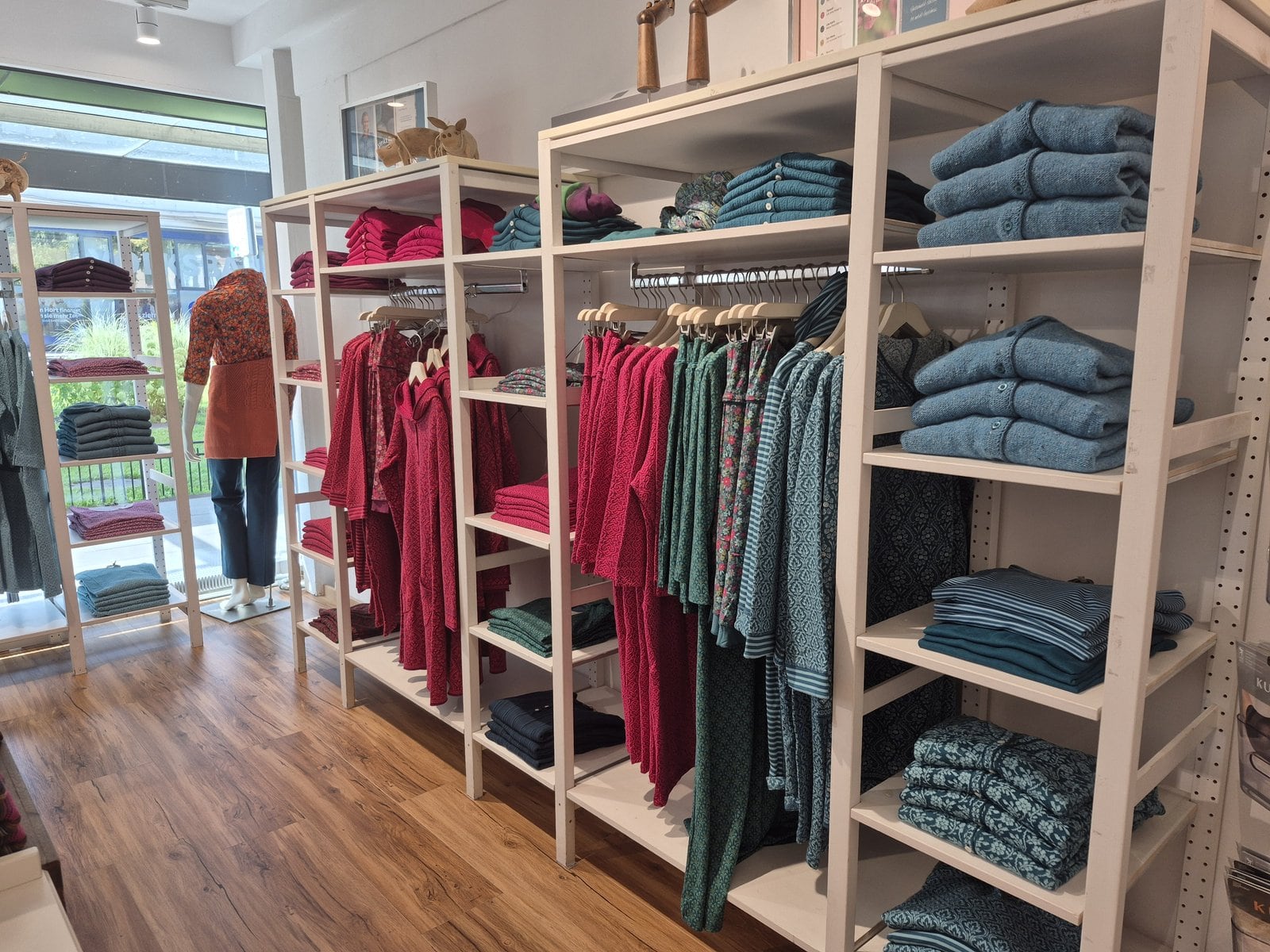 Innenraum der Checkpot Boutique in Wien-Hietzing mit Kleiderständern und Holzregalen.